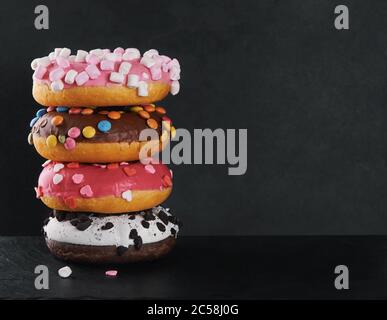 stack of multicolored sweet doughnuts with sprinkles Stock Photo