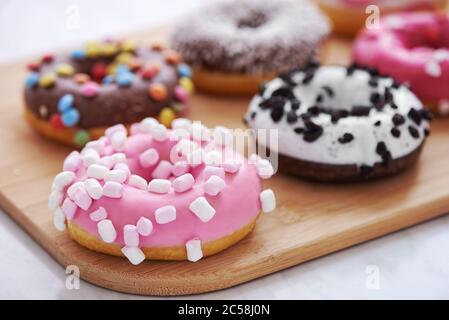 mix of multicolored sweet doughnuts with sprinkles. close up Stock Photo