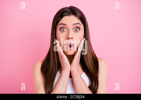 Closeup photo of terrified shocked lady long hairdo look speechless open mouth listen bad news arms on cheeks wear casual white singlet isolated Stock Photo