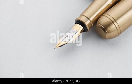 Old golden Fountain Pen on a white paper sheet with copy space Stock Photo
