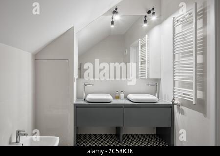 White, attic bathroom with two basins and big mirror Stock Photo