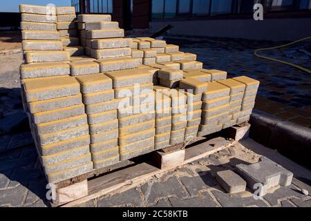 the yellow paving slabs folded in a pile one on top of another on a sunny day, side view close up. Stock Photo