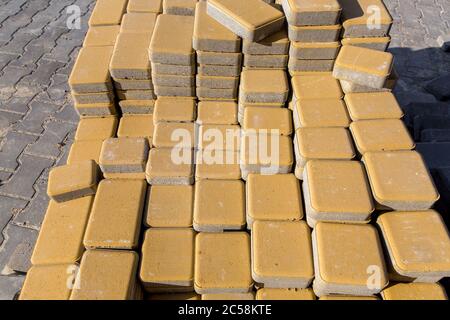 repair yellow paving slabs piled in a pile one on top of another on a sunny day, close up. Stock Photo