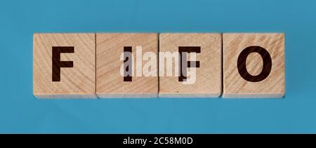 FIFO First in, first out word on wooden cubes on a dark wood background. Accounting, Business Concept image Stock Photo