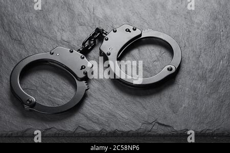 Old black handcuffs on stone background Stock Photo