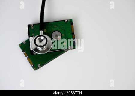 A hard disk with a stethoscope isolated on white background. Recovery and Data Safety Stock Photo