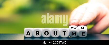 Hand turns dice and changes the expression "about me" to "about you". Stock Photo