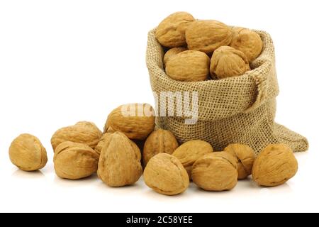 fresh walnuts in a burlap bag e on a white background Stock Photo