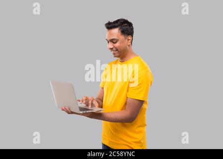 Indian Man Using Laptop. Home orders, Quarantine delivery, Shopping Online, Freelance Worker Concept. Stock Photo