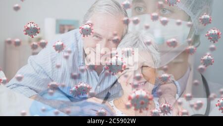 Covid-19 cells against doctor wearing face mask and senior couple embracing each other Stock Photo
