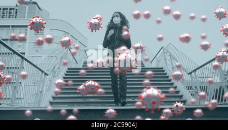 Covid-19 cells against woman walking down the stairs Stock Photo