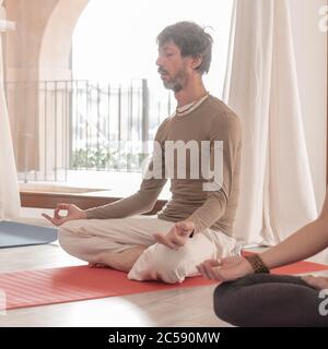 Yoga teachers sitting in the lotus position with their eyes closed. Group of people practicing Yoga. How to Keep Your Arms in the Air for a Kriya or M Stock Photo