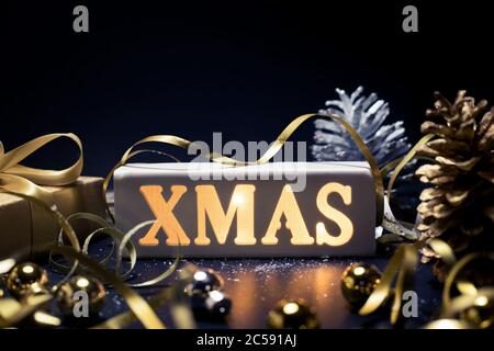Merry christmas,xmas and celebration concepts with xmas lightbox text and ornament in golden color on dark background.winter season and anniversary da Stock Photo