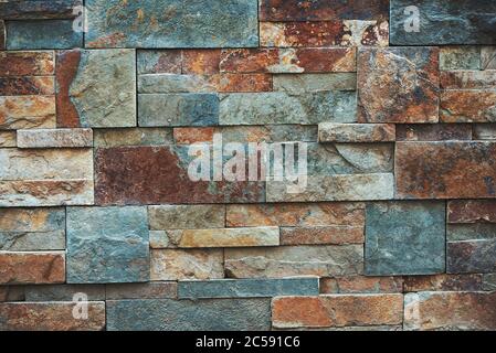 Natural stone wall texture for background. Teal and orange colors. Stock Photo
