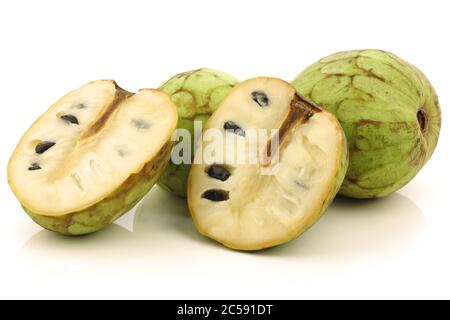 fresh cherimoya fruits (Annona cherimola) and a cut one on a white background Stock Photo