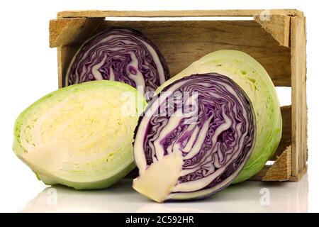 freshly cut red and white  cabbage in a wooden crate on a white background Stock Photo