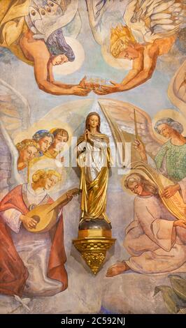 BARCELONA, SPAIN - MARCH 4, 2020: The modern statue and fresco as the detail of Coronation in church Iglesia Sant Angel Custodi from 20. cent. Stock Photo