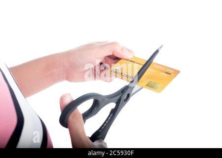 Close up young woman hand cutting up a credit card with scissors to stop spending on shopping at the white background Stock Photo