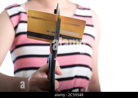 Portrait of young woman cutting up a credit card with scissors to stop spending on shopping at the white background Stock Photo