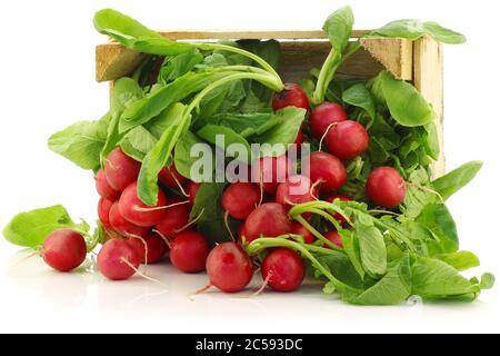 fresh radishes in a wooden crate on a white background Stock Photo