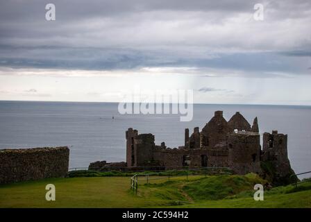 The Dunluce Castle sorrounded by sea, rocks and cloudy days with rain on its way. Stock Photo