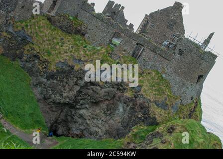 The Dunluce Castle sorrounded by sea, rocks and cloudy days with rain on its way. Stock Photo