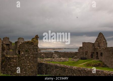 The Dunluce Castle sorrounded by sea, rocks and cloudy days with rain on its way. Stock Photo