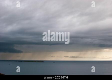 The Dunluce Castle sorrounded by sea, rocks and cloudy days with rain on its way. Stock Photo