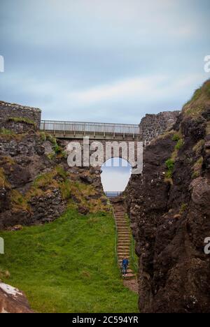The Dunluce Castle sorrounded by sea, rocks and cloudy days with rain on its way. Stock Photo