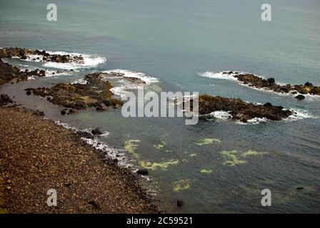 The Dunluce Castle sorrounded by sea, rocks and cloudy days with rain on its way. Stock Photo