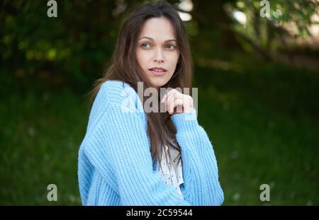 pretty woman in blue knitted sweater. Outdoors portrait Stock Photo