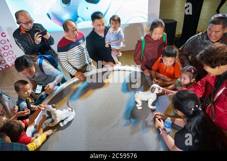 SHENZHEN, CHINA - CIRCA APRIL, 2019: people play with Sony's Aibo robot dog at Sony Expo 2019 at UpperHills Mall in Shenzhen, China. Stock Photo
