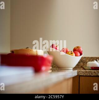 Shot of fresh apples in a white bowl over kitchen counter Stock Photo
