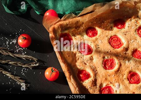 Italian classic focaccia bread with tomatoes cherry. Top view. Stock Photo