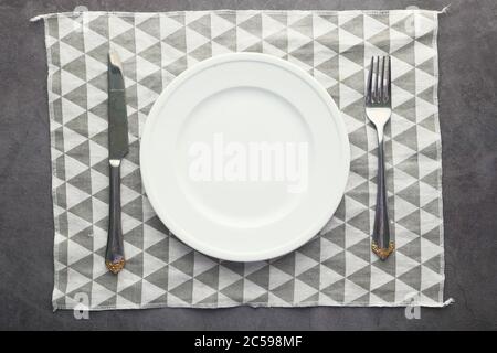 Fork and knife with empty plate, top down  Stock Photo