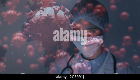 Covid-19 cells against doctor wearing face mask Stock Photo