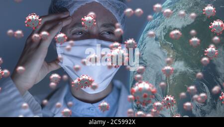 Covid-19 cells and globe against scientist wearing face mask Stock Photo
