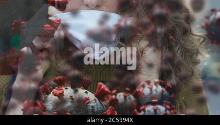 Covid-19 cells against woman wearing face mask Stock Photo