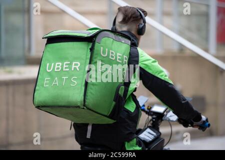 Uber Eats rider and his green back bag Stock Photo - Alamy