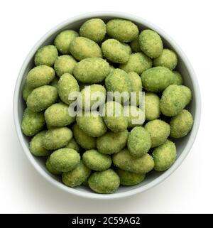 Wasabi coated peanuts in a white ceramic bowl isolated on white. Top view. Stock Photo