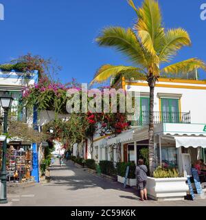 PUERTO DE MOGAN, GRAN CANARIA - FEB 19, 2014: Street with white houses colonia shown in Puerto de Mogan, Spain.  Favorite vacation place for tourists Stock Photo