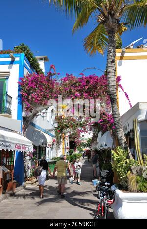 PUERTO DE MOGAN, GRAN CANARIA - FEB 19, 2014: Street with white houses colonia shown in Puerto de Mogan, Spain.  Favorite vacation place for tourists Stock Photo