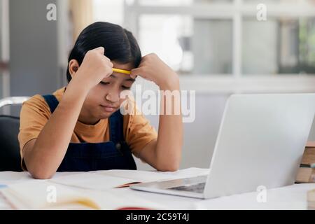 Happy asian girl learning online at home. Education and e-learning concept. Stock Photo