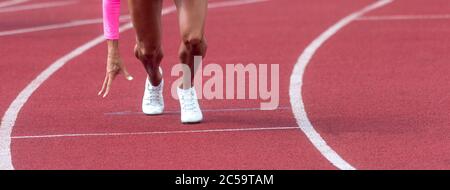 Sport and fitness runner woman athlete on red run track with white running shoes. Sports and healthy lifestyle concept. Stock Photo