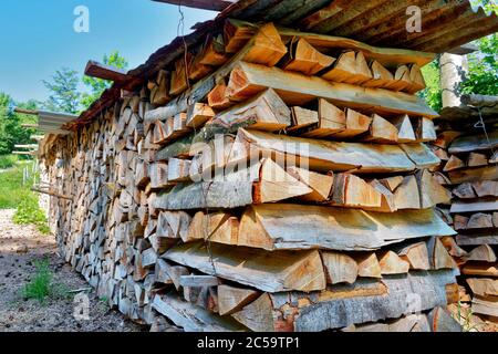 Firewood stacked in a large pile to be used during the winter Stock Photo