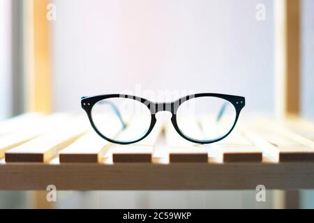 Glasses on a shelf and on a white background. Glasses at home concept. Reading glasses. Stock Photo