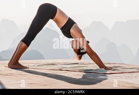 beautiful woman practising yoga above the kast mountains of Yangshuo Stock Photo