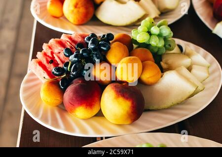 Plates with fruits on a wooden table closeup Stock Photo