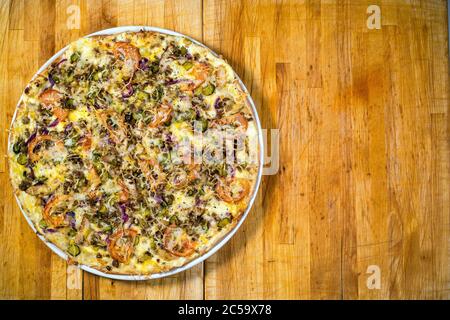 Pizza with tomatoes on a wooden table Stock Photo