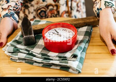 Alarm clock and hammer on a tray closeup Stock Photo